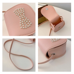 Detail view of pink mini crossbody bag with pearl bow design and magnetic snap closure