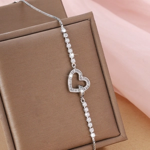 Detailed view of silver heart bracelet with micro-pave cubic zirconia on a jewelry box