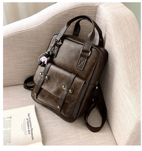 Detail view of vintage dark brown leather backpack with magnetic flap and metal buckles
