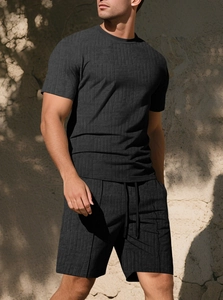 Detail of men's black waffle knit shorts with adjustable drawstring and textured fabric