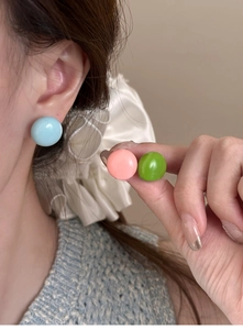Boucles d'oreilles boules colorées en rose, bleu ciel et vert sur modèle avec fini brillant