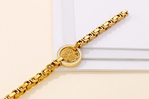 Detail of gold-plated Byzantine chain bracelet with iced-out Hamsa Hand pendant