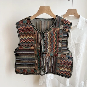 Close-up of ethnic style woven vest with geometric patterns and fringe tassel detail