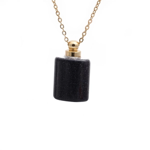 Detail of a sparkling black semi-precious stone perfume bottle pendant with gold chain