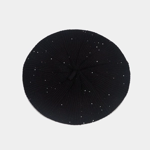 Detail shot of black knitted beret featuring sparkling silver sequins and soft wool texture