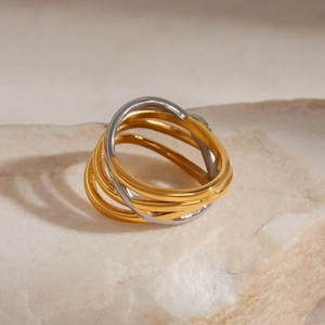 Macro shot of 18K gold and silver two-tone multi-layered twisted ring on stone plate