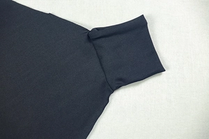 Detail of navy blue knit high neck top showing premium fabric texture and stitching