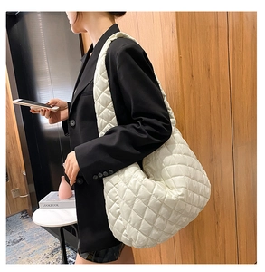 Detail of a white quilted crossbody bag with soft padded texture and rhombus pattern
