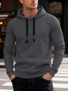 Detail of dark grey hoodie featuring waffle texture fabric and adjustable drawstring hood