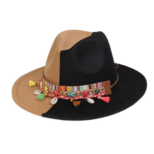 Detail of two-tone wool felt hat featuring woven band with shells and colorful tassels