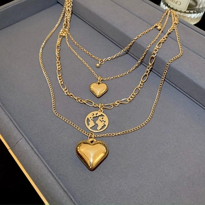Chic layered gold necklace with heart charms and a cutout world map globe pendant