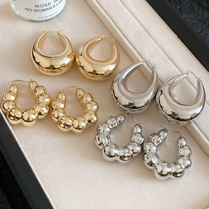 Detailed set of gold and silver teardrop and beaded hoop earrings on velvet