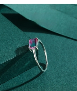 Macro view of a rectangular emerald-cut gradient tourmaline stone on a silver ring