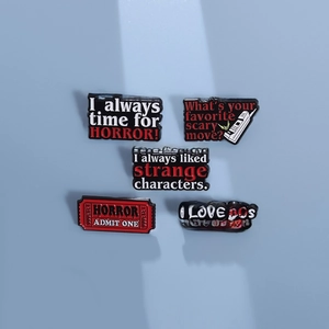 Set of 5 horror movie enamel pins featuring spooky quotes on a blue background