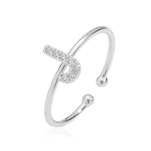 Close-up of silver open ring with J-letter design pavé set with sparkling cubic zirconia