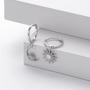 Detailed view of asymmetric S925 silver hoop earrings with zircon sun and moon charms