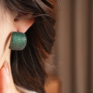Gros plan de boucles d'oreilles vintage avec zircons verts sur mannequin