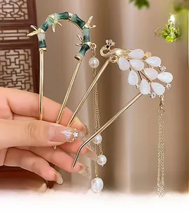 Détail de pics à cheveux de style chinois avec glands en perles et motifs de paon