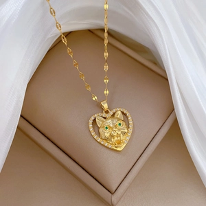 Elegant gold heart pendant necklace with crystal accents and green-eyed cat sculpture