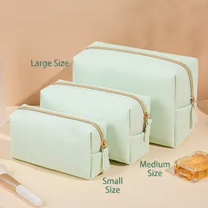 Three-piece mint green octagonal cosmetic bag set in crosshatch leather with gold zippers