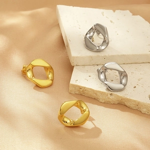 Dettaglio di orecchini geometrici irregolari placcati in oro 18K e argento su pietra