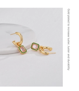 Dettaglio di orecchini ottagonali placcati oro con smalto verde e zircone rosa