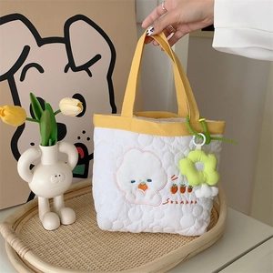 Quilted cotton handbag with floral embroidery and green plush flower charm detail