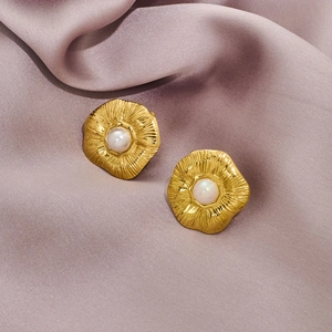 Vintage gold plated flower earrings with white pearls on a soft silk background