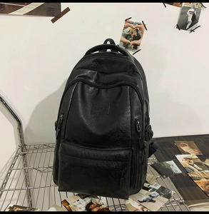 Dettaglio di uno zaino in pelle PU nera con tasca a zip in un ambiente in stile street