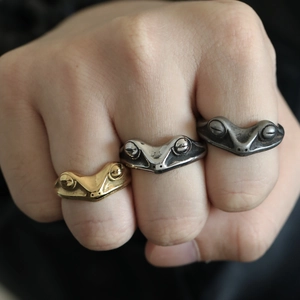 Detail showing vintage titanium steel frog rings in gold, silver, and matte finishes