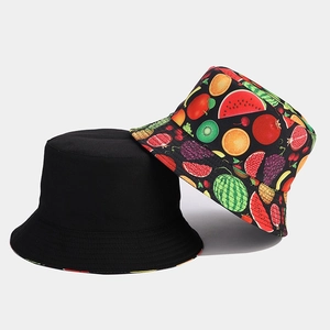 Detail view of cotton bucket hats featuring minimalist black and tropical fruit print patterns