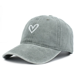 Detailed close-up of white heart embroidery on a vintage washed grey cotton baseball cap