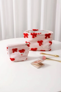 Pink sherpa cosmetic bag set with 3D red bow detailing and gold flower zipper puller