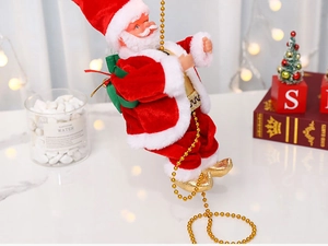 Detailansicht vom plüschigen Weihnachtsmann an goldener Perlenkette auf festlichem Tisch