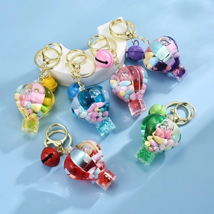 Macro detail of six colorful hot air balloon resin keychains with gold rings and bells