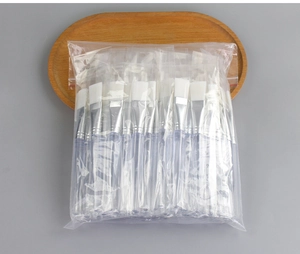 Bulk pack of clear handle facial mask brushes with white bristles in a clear bag
