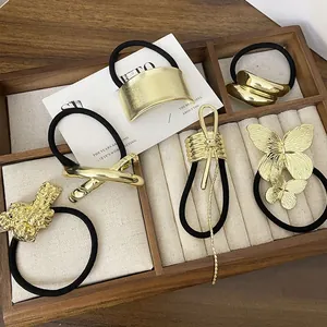 Close-up of a 6-piece golden alloy hair tie set with butterfly and geometric designs