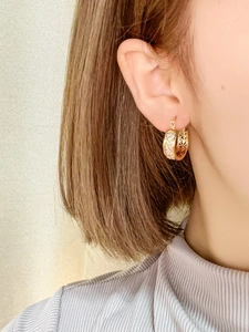 Nahaufnahme goldener geometrischer Ohrringe mit Zirkonia und hohlem Vintage-Muster