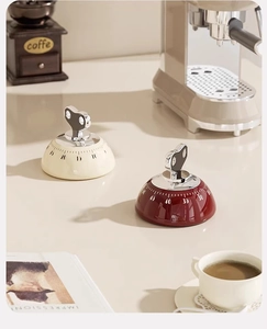 Macro shot of retro mechanical kitchen timers with 60-minute scale in cream and burgundy