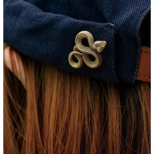 Detailed macro view of vintage gold snake brooch featuring intricate scale textures