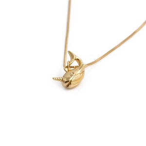 Gold plated copper narwhal pendant necklace with zircon stones on white background