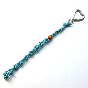 Detail of teal hand-woven rope keychain with wooden bead and heart-shaped metal clasp