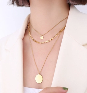 Close-up of triple-layered 18K gold plated titanium steel necklaces on a model