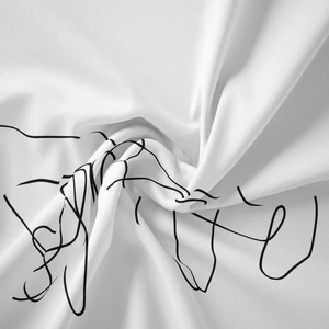 Macro shot of white cotton fabric with black abstract line art in a spiral fold design