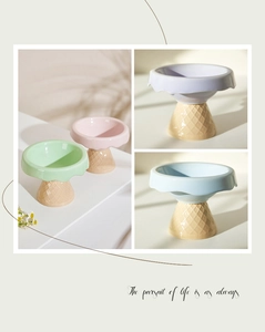 Close-up of pastel ceramic pet bowls with ice cream cone base and scalloped edges