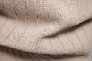 Macro della trama a maglia a coste verticali su un cardigan beige in tessuto