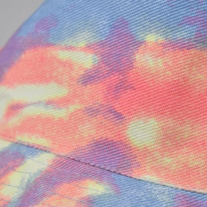 Macro shot of colorful tie-dye bucket hat showing high-density cotton twill fabric texture