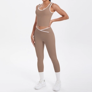 Detail of coffee brown yoga set featuring white piped trim and waist crossover design
