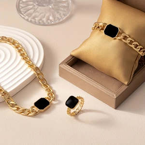 Gold chain jewelry set with black octagonal charms including necklace bracelet and ring