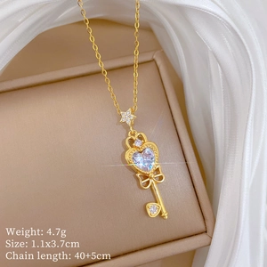 Detailed shot of bow-knot key necklace with heart zircon and star charm on gold chain